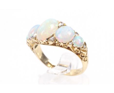 A late Victorian 18ct gold and opal five stone carved half-hoop ring with rose diamond points. The five graduated oval caboch