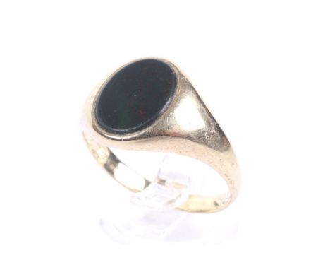 A vintage 9ct gold and bloodstone oval signet ring. The oval bloodstone panel rub-over set between tapering shoulders on a D-