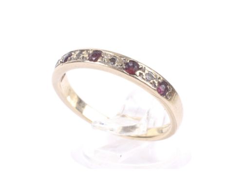A vintage 9ct gold, ruby and diamond nine stone half-eternity ring. The five small round mixed-cut rubies spaced by small eig