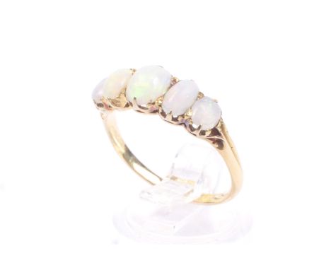 An early 20th century gold and opal five stone ring. The graduated oval cabochon white opals each claw set on an unmarked gol