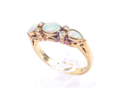A vintage 18ct gold, opal and diamond dress ring. The three oval and pear-shaped cabochon white opals display a pleasing play