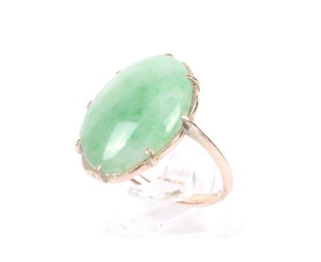 An early 20th century rose gold and jadeite single stone ring. The oval cabochon light-mottled jadeite, approx. 19mm x 13.3mm