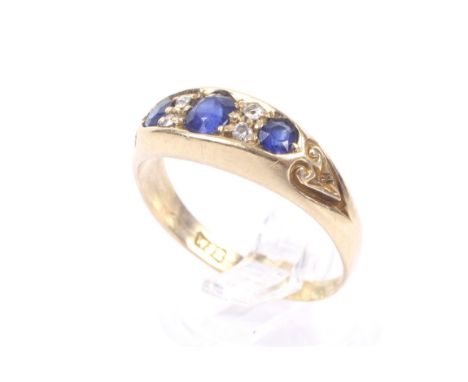An early 20th century gold, sapphire and diamond ring. The three graduated round mixed-cut sapphires spaced by pairs of small