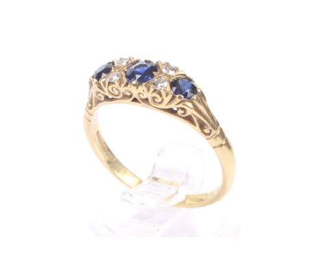 A vintage 18ct gold, sapphire and diamond ring in Victorian carved half-hoop style. The three graduated round mixed-cut sapph