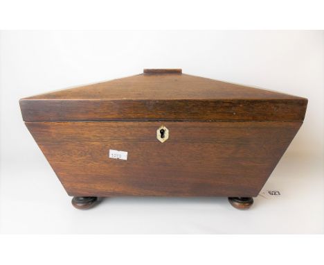 19th Century mahogany tea caddy of sarcophagus form, the hinge-lid revealing three compartments with stained turned ivory fin