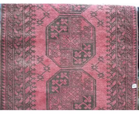 Eastern wool runner with a row of seven medallions within portable geometric borders upon a red ground, length 2.5m; together