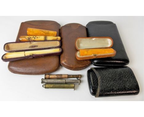 Collection of antique smoking-related items, including two amber cheroot holders, an ivory gold mounted cigarette holder with