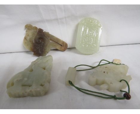 Four small objects carved from pale green jade-type stone - a buckle engraved with two serpents (7cm x 4cm); an oblong tablet