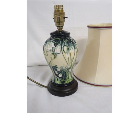 Moorcroft pottery baluster table lamp, green ground graduation to cream, tube lined decoration of snow drops, on a circular d