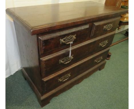 A dark stained oak chest of two short over two long drawers, the drawer fronts with replacement pierced brass brackets and sw
