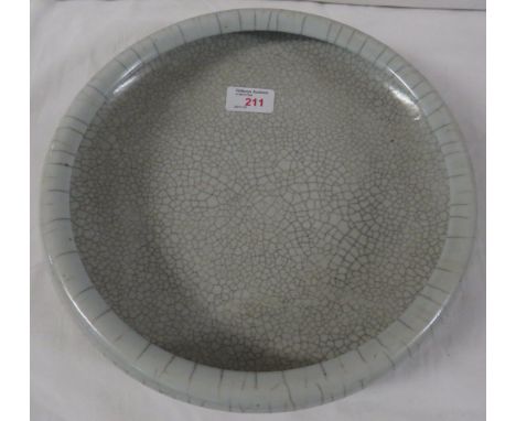 Ceramic bowl in the style of Chinese guan ware with pale grey craquelure glaze with inwardly turned lip, the base with unglaz