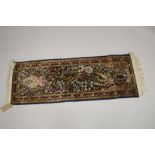 A SMALL PERSIAN PART SILK RUNNER dark blue ground with a Tree of Life design. 3ft 10ins x 1ft 4ins.