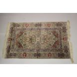 A GOOD SMALL PERSIAN SILK RUG cream ground with all over floral design. 5ft x 3ft 1ins.