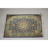 A GOOD SMALL PERSIAN SILK RUG blue ground with stylised floral decoration, with a similar green