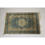 A GOOD SMALL PERSIAN SILK RUG turquoise ground with fine floral decoration. Signed. 4ft 10ins x