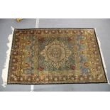 A GOOD PERSIAN SILK CARPET rich green ground with central circular floral medallion decoration all