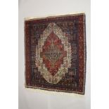 A PERSIAN WOOL CARPET cream, red and blue ground with all over stylised decoration. 4ft 9ins x 4ft