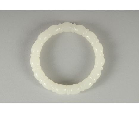A CARVED TWIST WHITE JADE BANGLE.  8cm diameter.