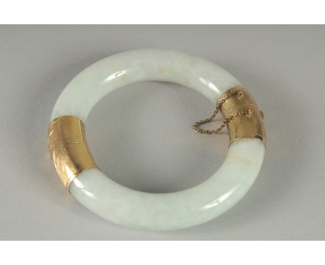 A 9CT GOLD MOUNTED JADE BANGLE.  3ins diameter.