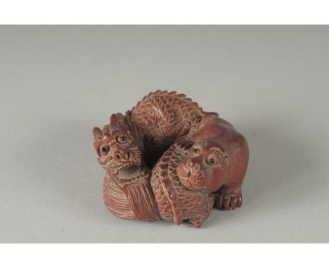 A CARVED WOOD BEAR AND DRAGON NETSUKE, Signed, 2ins.