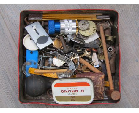 A tin of horology tools and materials including case opener, rules, stepped lathe chuck etc