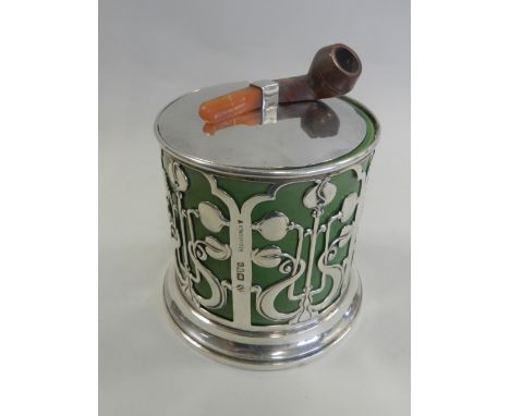 An early 20th century silver mounted tobacco box and cover hallmarked Chester, circular form with pierced Art Nouveau design 