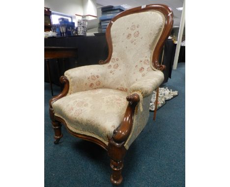A Victorian mahogany framed spoon back armchair later upholstered on ring turned legs and ceramic castors 