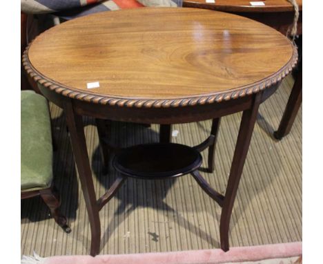 A mahogany oval occasional table with undertier shelf and piecrust edging