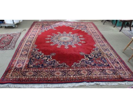A Louis De Poortere Khorsabad wool carpet of Persian design with red ground, central rose motif. 255 x 343 cm&nbsp;