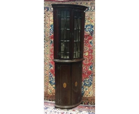 MAHOGANY TWO STAGE BOW FRONT CORNER CUPBOARD, with dentil cornice over two astragal glazed doors, enclosing shelved interior,