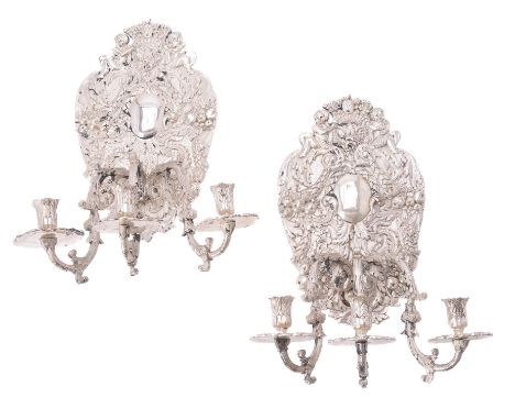 A pair of silvered metal three light sconces in William and Mary taste, circa 1900, each with three acanthus scrolled arms is