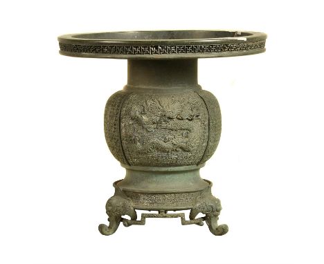 A Japanese Bronze Ikebana Vase with bulbous body cast with dragons on a diaper ground, rising to a broad mouth with manji dia