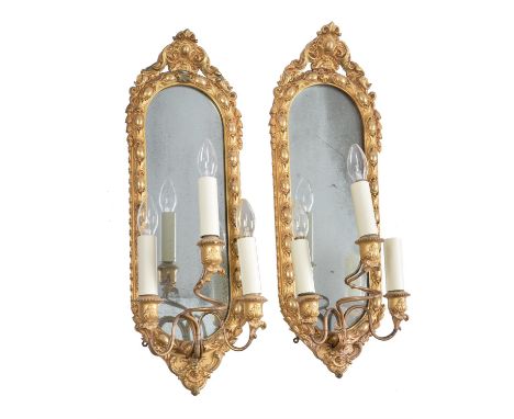 A set of four Victorian carved, giltwood and composition three-light girandoles, third quarter 19th century, the oval frames 