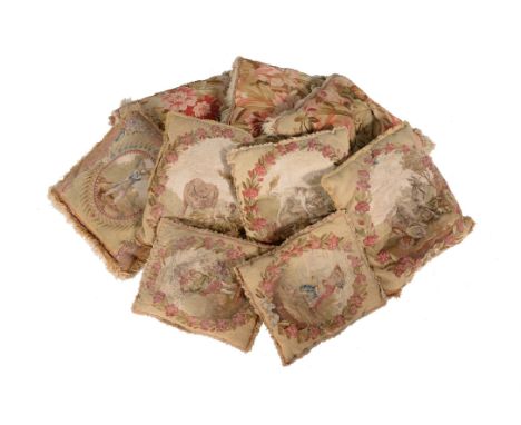 A group of six cushions incorporating Aubusson style tapestry fragment facings, each with a pastoral vignette within a floral
