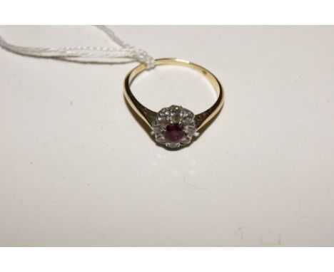 AN 18CT GOLD RING with central ruby surrounded by diamonds