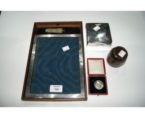 A SILVER PHOTOGRAPH FRAME with engine turned decoration, together with a silver cigarette box of plain form, a mother of pear