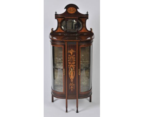 AN EDWARDIAN MAHOGANY AND INLAID BOW FRONTED CABINET, the top having inset oval mirror surrounded by floral inlay above a cen