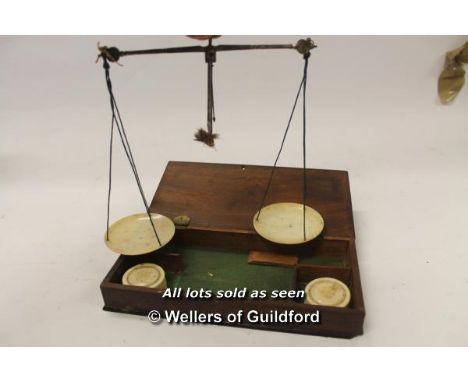 A set of 19th Century balance scales with ivory dishes, with two turned bone cylindrical boxes containing weights, in fitted 