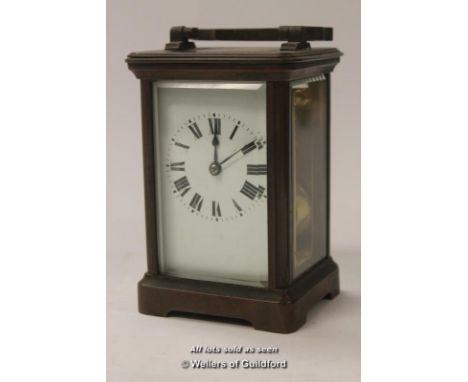 A French brass carriage clock with white enamel dial, Roman numerals, striking on a gong, 15cm including handle.