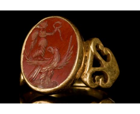 Ca. 100-300 AD. Roman. A beautiful gold ring with a circular band with broad shoulders decorated with stylized openwork scrol