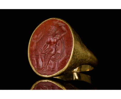 Ca. 100-300 AD. Roman. A beautiful gold ring with a circular band, flared shoulders, and an oval bezel set with large oval re