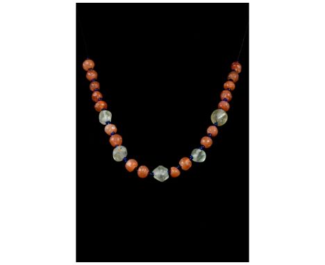 Ca. 100-300 AD. Roman. A restrung and fully wearable necklace made of a single string of white and blue glass beads and carne