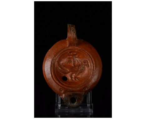 Ca. 300-400 AD. Roman. A wonderfully preserved, mould-made terracotta lamp with a round nozzle, a round discus with concentri