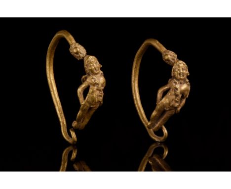 Ca. 300-100 BC. Hellenistic. A finely rendered matching pair of gold earrings, each formed from a circular wire hoop, which t