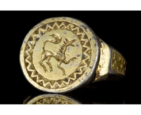 Ca. 1300-1500 AD. European. A beautiful gilded silver ring with a circular band and flared shoulders decorated with a cross p