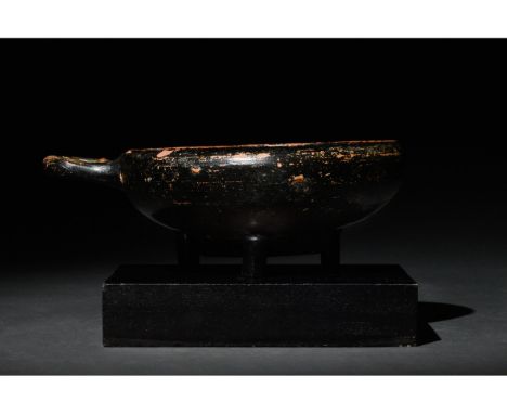 Ca. 400-300 BC. Apulian. A deep cup on a wide ring foot and a looped handle featuring a lustrous black glaze. Good condition.