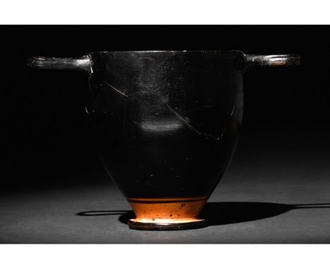 Ca. 400-300 BC. Apulian. An elegant black glazed terracotta skyphos (drinking cup) with a rounded body on a ring base; just b