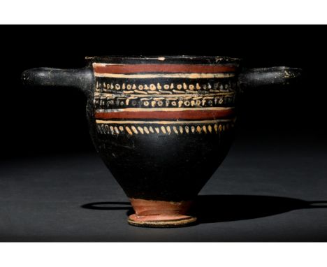 Ca. 400-300 BC. Apulian. An elegant Gnathian ware skyphos (drinking cup) with a rounded body on a low flanged ring base and e