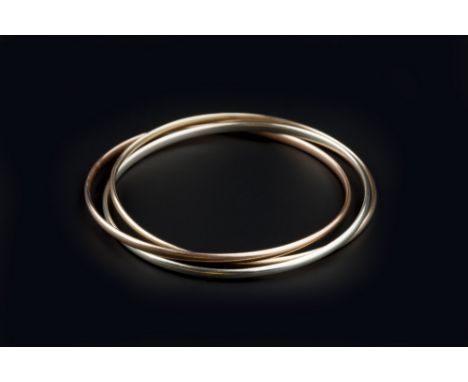 A 9CT THREE COLOUR GOLD BANGLE, comprising three entwined hoops of yellow, white and rose gold, inner diameter 6.2cm