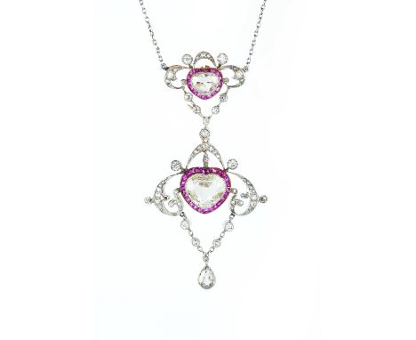 AN EARLY 20TH CENTURY RUBY AND DIAMOND PENDANT NECKLACE,  comprising two openwork cartouche panels, each centred with a heart